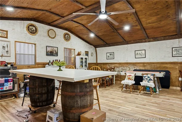 a dining hall with stainless steel appliances granite countertop a stove and a dining table with chair