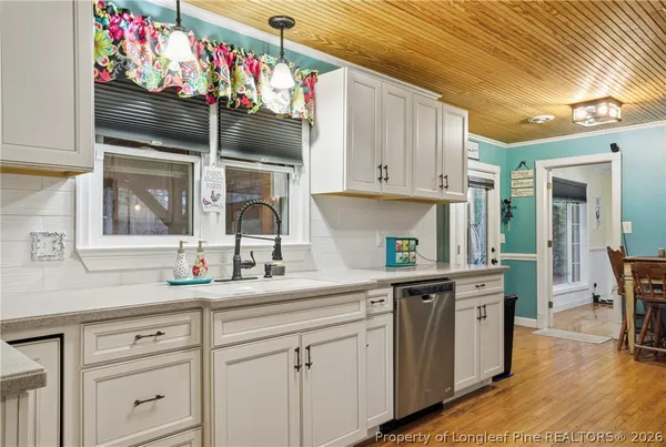 a kitchen with granite countertop white cabinets and window