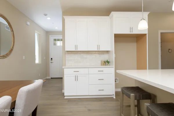 a kitchen with a white cabinets and chairs