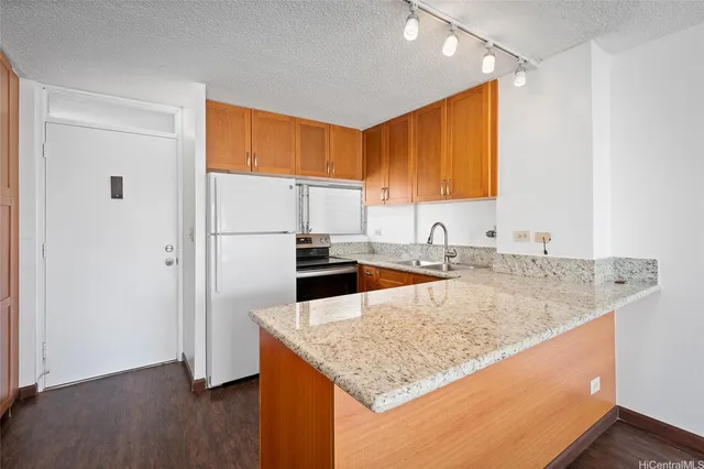 a kitchen with stainless steel appliances granite countertop a sink refrigerator and cabinets