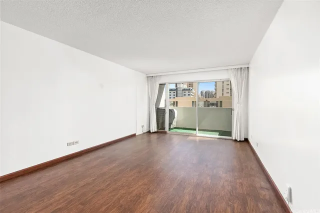 an empty room with wooden floor and glass door