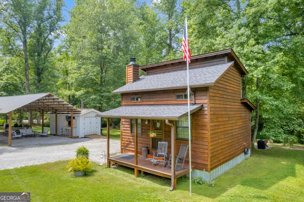 a view of a house with a yard and sitting area
