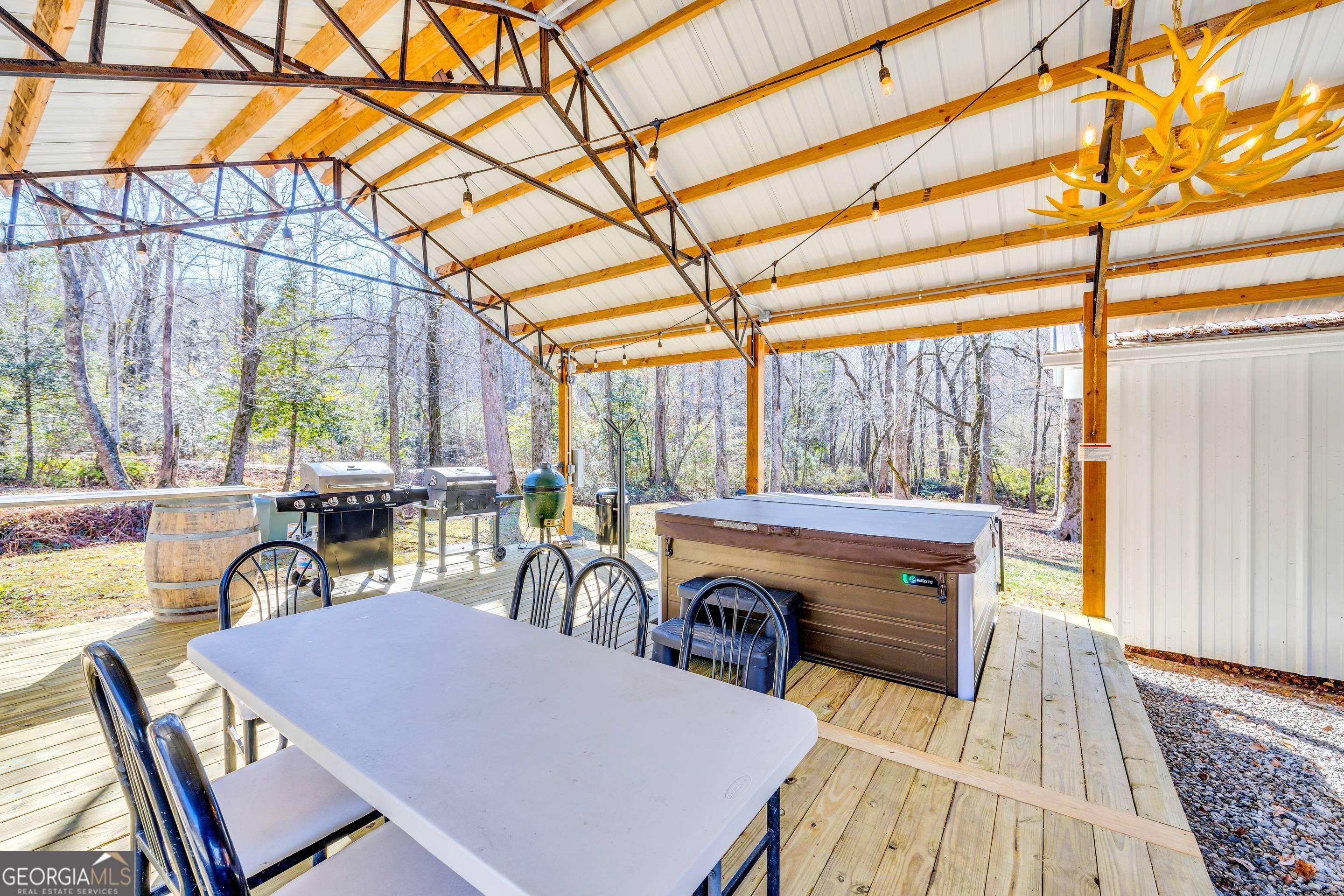 284 Duncan Bridge Road Sautee Nacoochee, GA 30571 - Photo 41 of 69 a view of a patio with table and chairs a barbeque with wooden floor and fence