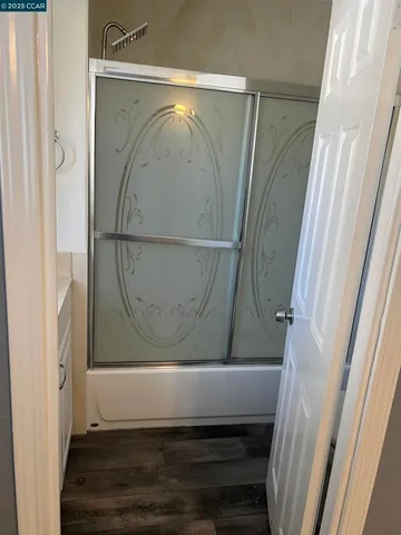 a bathroom with a glass shower door and a sink