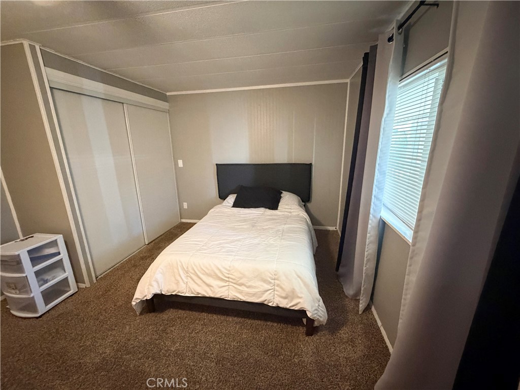 1550 Rimpau Avenue, Unit 138 Corona, CA 92881 - Photo 14 of 29 a bedroom with a bed and wooden floor