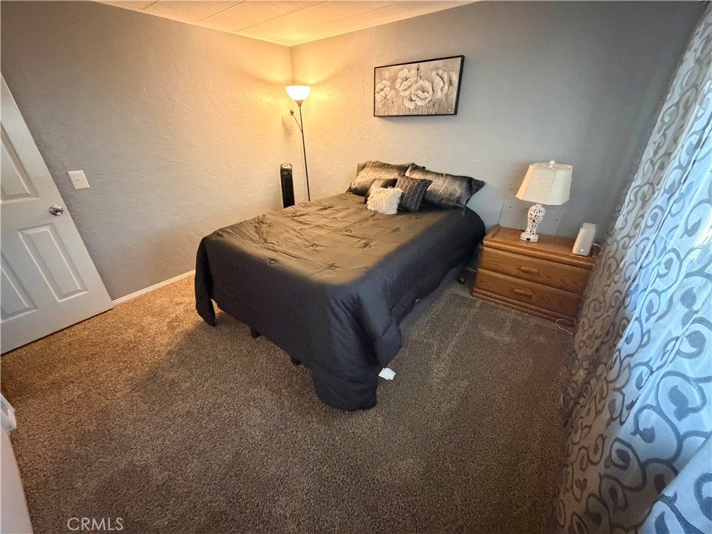 1550 Rimpau Avenue, Unit 138 Corona, CA 92881 - Photo 17 of 29 a bed sitting in a bedroom next to a window