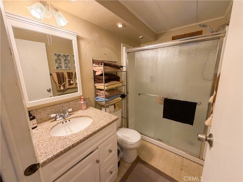 1550 Rimpau Avenue, Unit 138 Corona, CA 92881 - Photo 18 of 29 a bathroom with a granite countertop sink toilet and shower