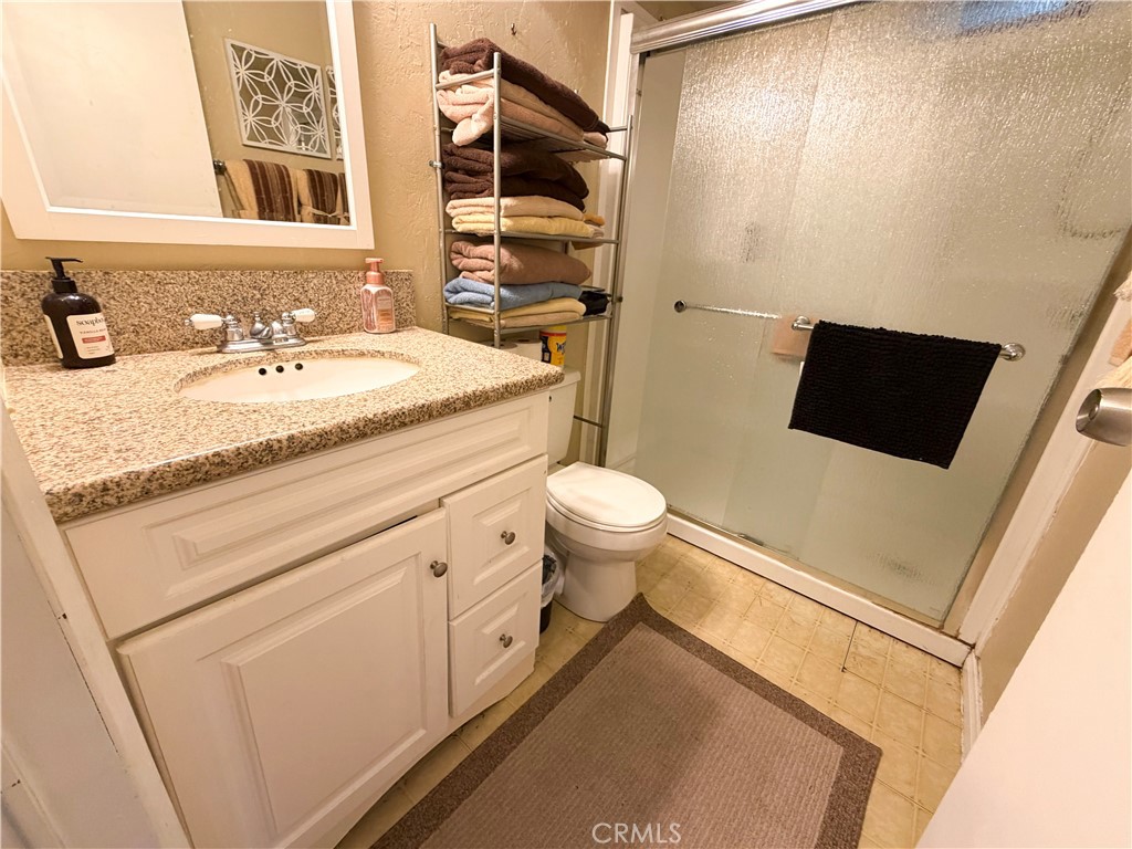 1550 Rimpau Avenue, Unit 138 Corona, CA 92881 - Photo 19 of 29 a bathroom with a granite countertop sink toilet and shower