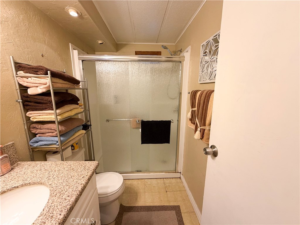 1550 Rimpau Avenue, Unit 138 Corona, CA 92881 - Photo 20 of 29 a bathroom with a granite countertop sink toilet and shower