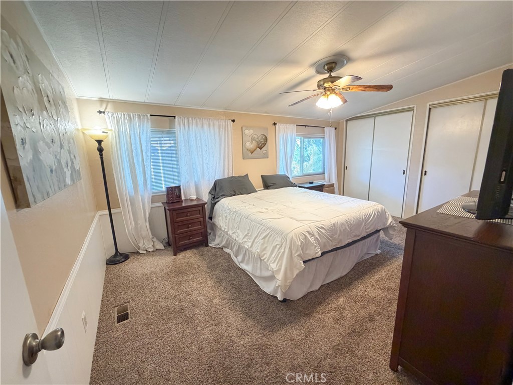 1550 Rimpau Avenue, Unit 138 Corona, CA 92881 - Photo 21 of 29 a bedroom with a large bed and a chandelier