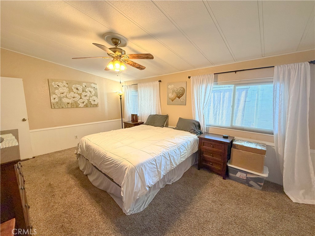 1550 Rimpau Avenue, Unit 138 Corona, CA 92881 - Photo 22 of 29 a spacious bedroom with a bed and a chandelier