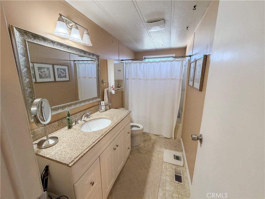 1550 Rimpau Avenue, Unit 138 Corona, CA 92881 - Photo 24 of 29 a bathroom with a sink a mirror and a shower