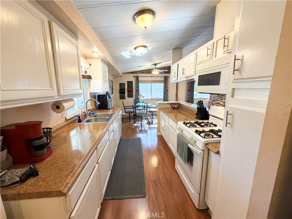 1550 Rimpau Avenue, Unit 138 Corona, CA 92881 - Photo 7 of 29 a kitchen with stainless steel appliances granite countertop a stove top oven a sink a counter space and cabinets