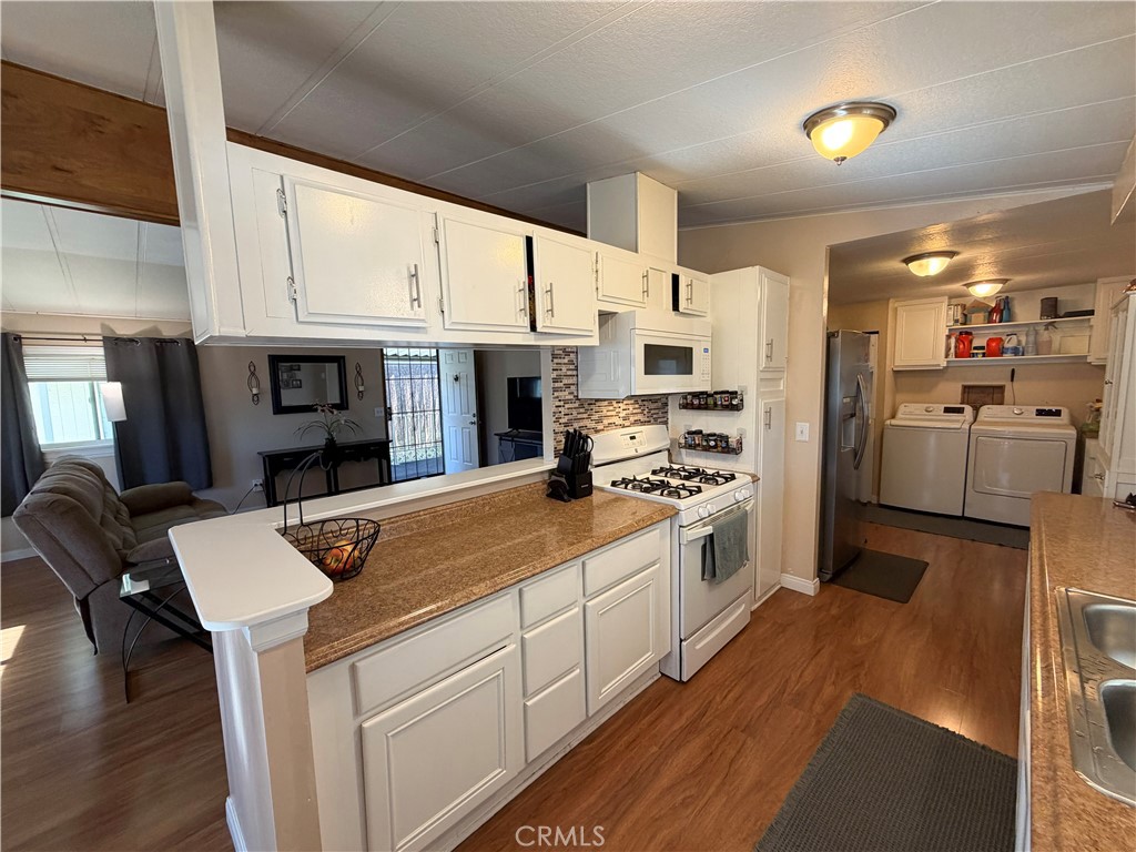 1550 Rimpau Avenue, Unit 138 Corona, CA 92881 - Photo 8 of 29 a kitchen with stainless steel appliances kitchen island granite countertop a stove refrigerator and cabinets