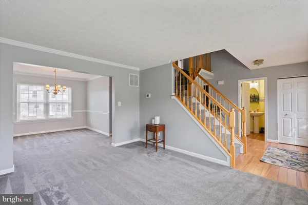 a view of an empty room with stairs and a window