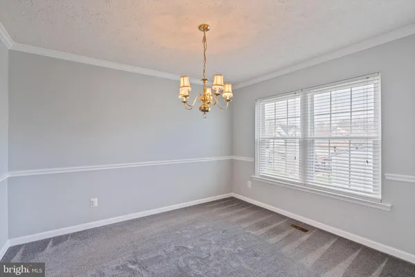 a view of a livingroom with a chandelier fan and windows