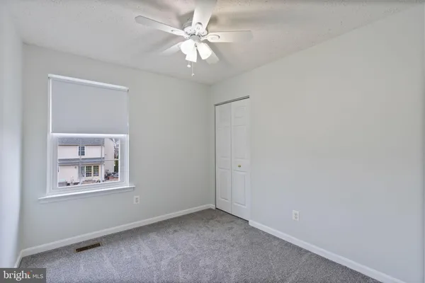 an empty room with a chandelier fan and a chandelier fan