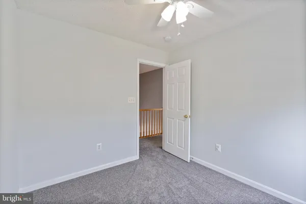 an empty room with a window and a ceiling fan
