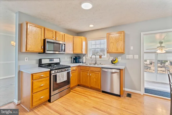 a kitchen with granite countertop wooden floors and stainless steel appliances