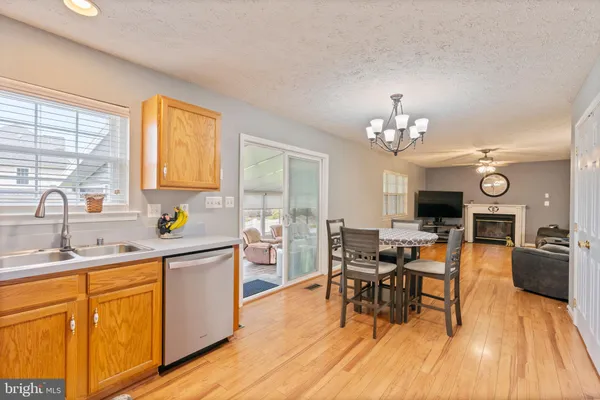 a view of a dining room with furniture a chandelier and wooden floor