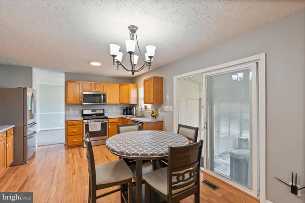 a view of a dining room with furniture a chandelier and wooden floor