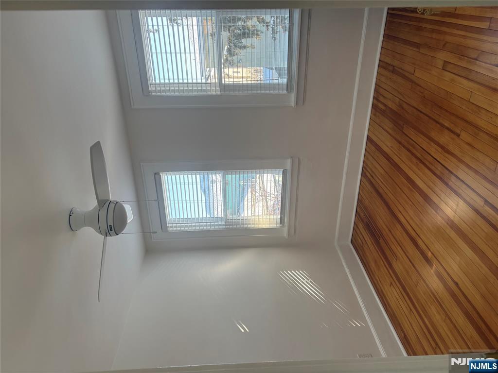 761 Hamilton Street, Unit 2 Harrison, NJ 07029 - Photo 1 of 14 a view of an empty room with wooden floor and a window