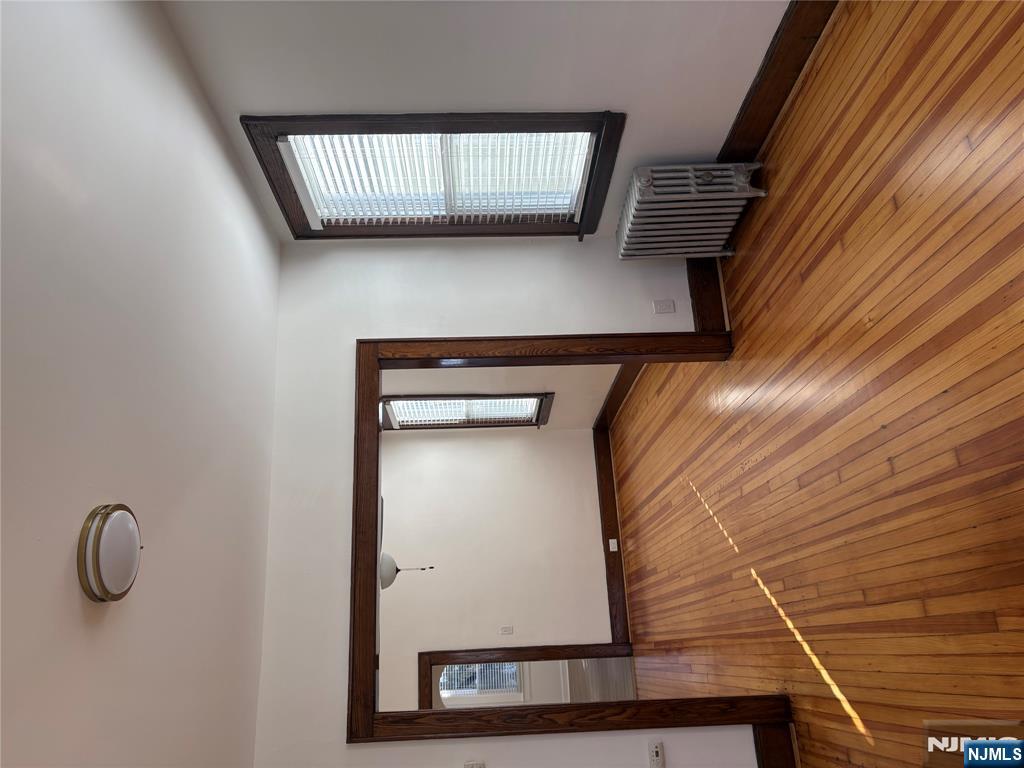 761 Hamilton Street, Unit 2 Harrison, NJ 07029 - Photo 13 of 14 a view of an empty room with wooden floor and a window