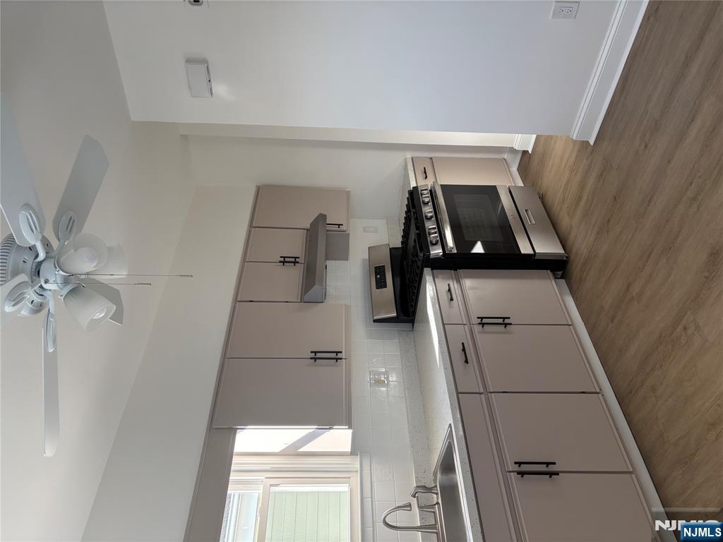 761 Hamilton Street, Unit 2 Harrison, NJ 07029 - Photo 3 of 14 a kitchen with a sink cabinets and stainless steel appliances