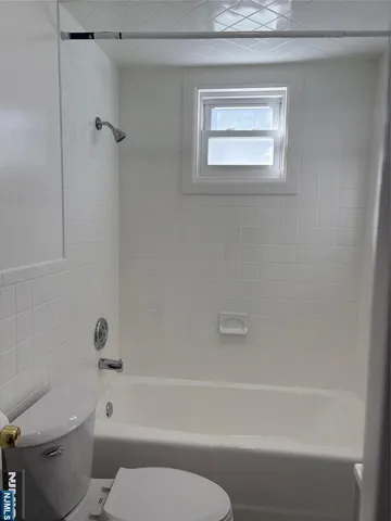 a bathroom with a toilet and a bath tub