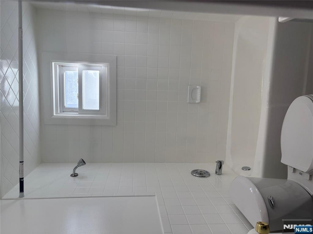 761 Hamilton Street, Unit 2 Harrison, NJ 07029 - Photo 5 of 14 a bathroom with a toilet and a bath tub