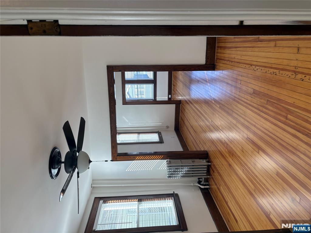 761 Hamilton Street, Unit 2 Harrison, NJ 07029 - Photo 9 of 14 a view of empty room with wooden floor and fan