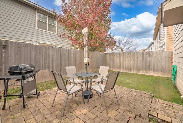 a view of a chairs and table in backyard of the house
