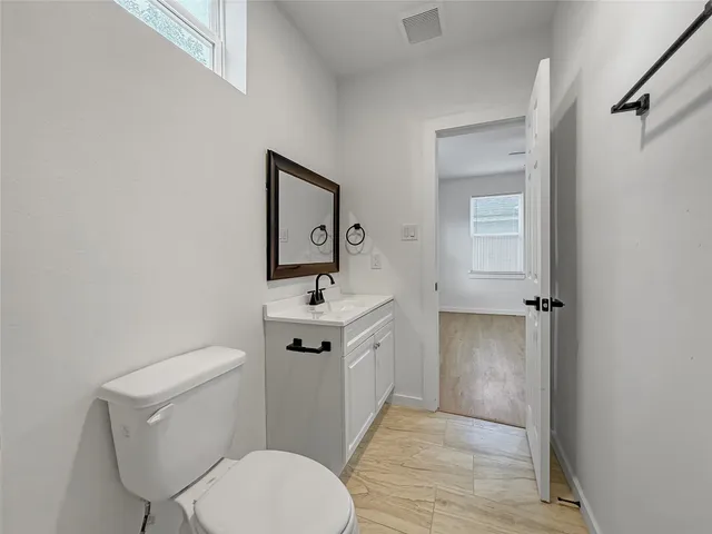 a bathroom with a toilet a sink and mirror