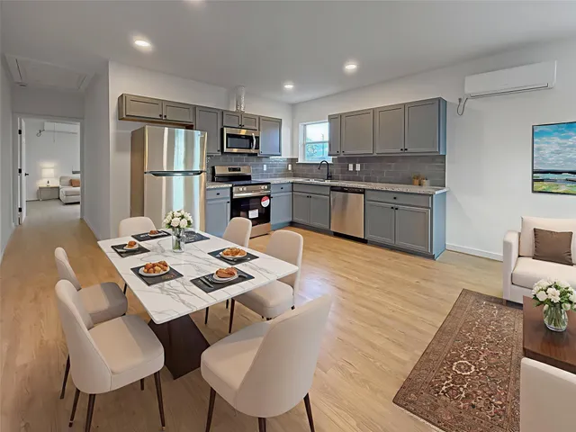 a open dining room with stainless steel appliances kitchen island granite countertop a dining table chairs and kitchen view
