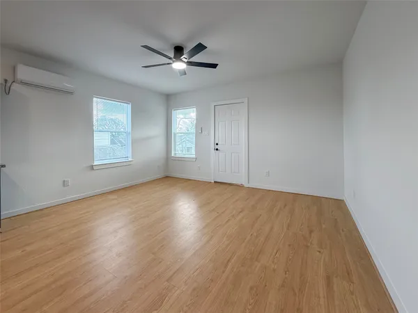 a view of a big room with wooden floor and windows