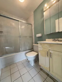 a bathroom with a toilet a sink a shower and mirror