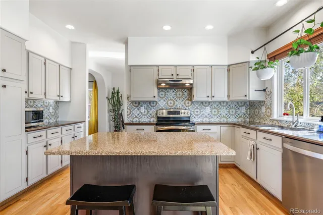 a kitchen with stainless steel appliances a sink stove and refrigerator