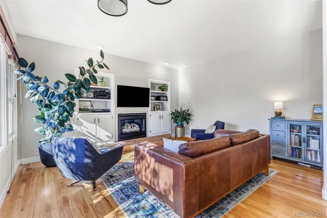 a living room with furniture a flat screen tv and a potted plant