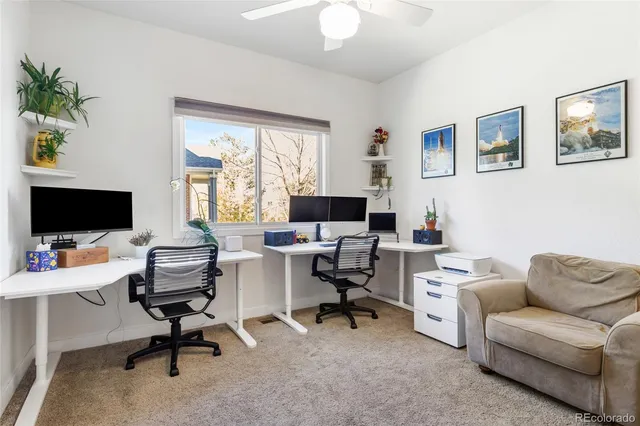 a view of a livingroom with workspace and a window