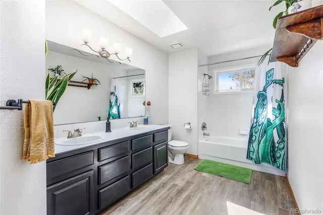 a bathroom with a double vanity sink mirror and tub