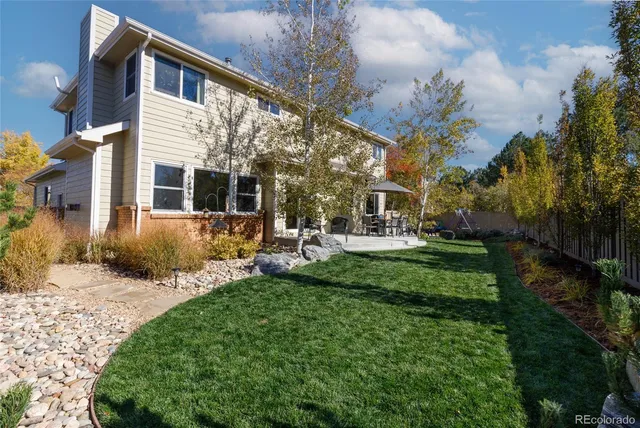 a view of a house with backyard and sitting area