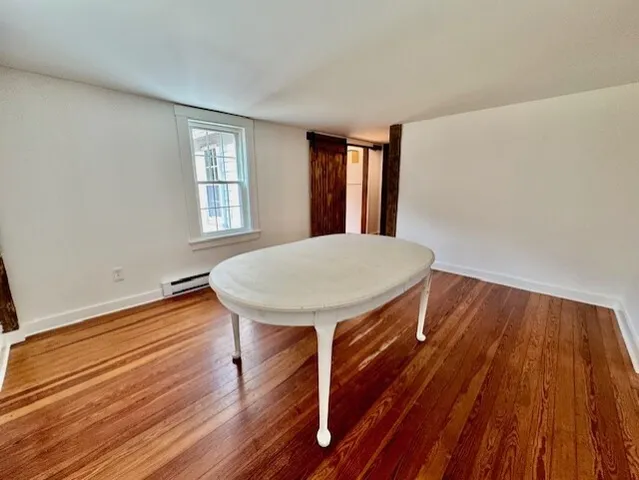 a view of a room with wooden floor and windows