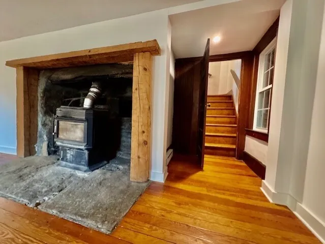 a view of a hallway with wooden floor and staircase