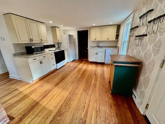 a kitchen with a sink wooden floor and stainless steel appliances