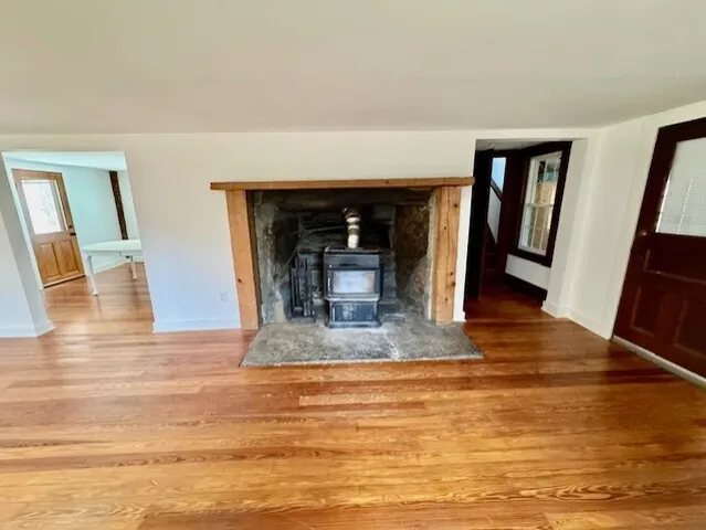 a view of a livingroom with wooden floor and a fireplace