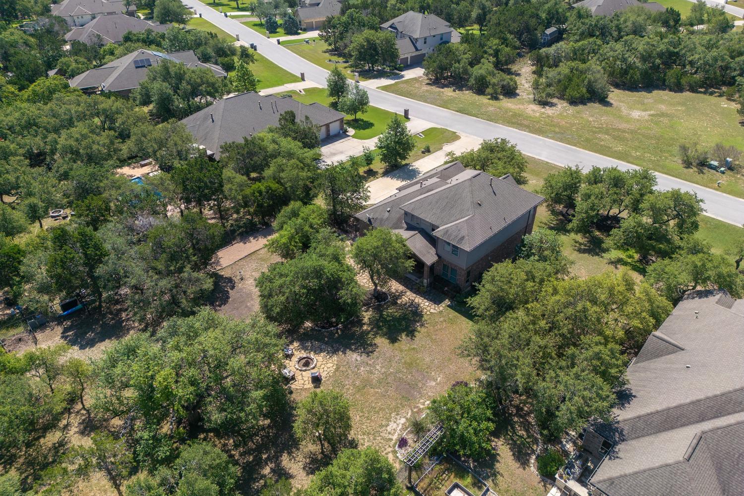 1135 Blue Ridge Drive Dripping Springs, TX 78620 - Photo 35 of 36 An aerial perspective showcases a large residence nestled within a verdant, treed neighborhood.