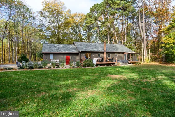 a front view of a house with a garden and trees