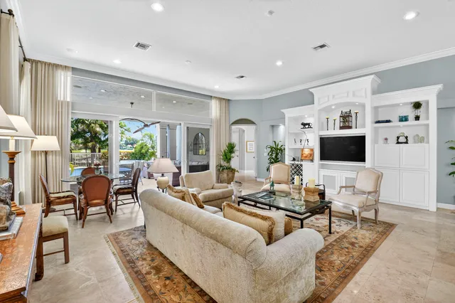 a living room with furniture a flat screen tv and a large window
