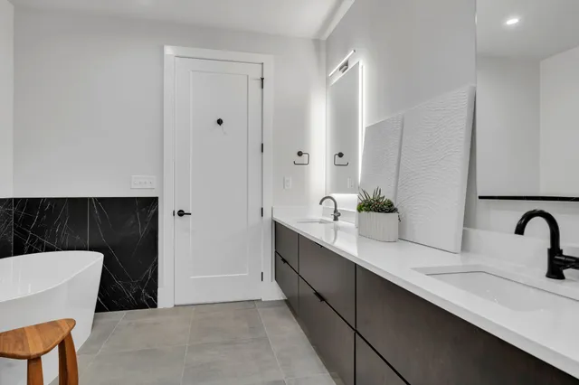 a bathroom with a double vanity sink and a mirror