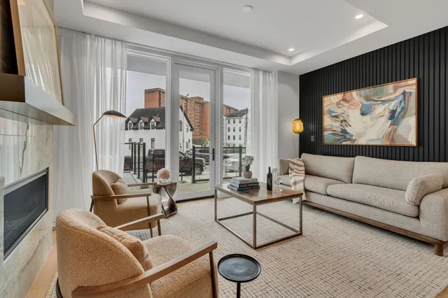 a living room with furniture a rug and a large window